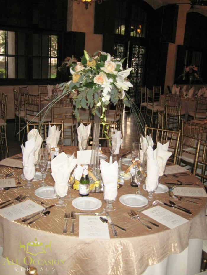 Ivory & White Elevated Centerpiece Rental displayed on elegantly set dining table with floral arrangements and fine diningware.