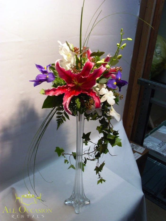 Pink Lily Pedestal Centerpiece Rental featuring elegant flowers in a tall pedestal vase.