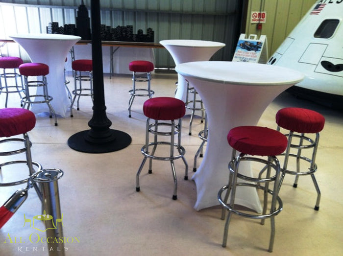 Elegant spandex cocktail tables with red stools for event rentals in Corona, ideal for parties and celebrations.