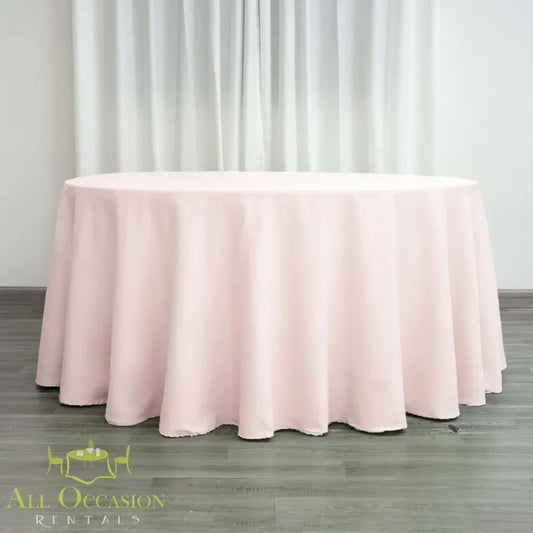 132 Inch Round Polyester Tablecloth Blush Pink draped elegantly over a large round table for special occasions.