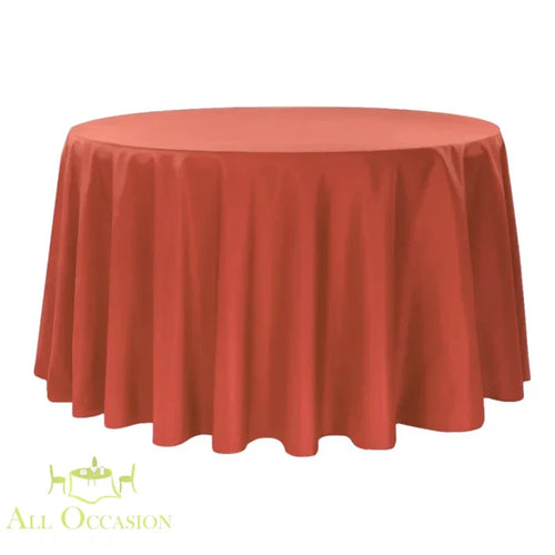 132 inch round polyester tablecloth burnt orange displayed on a large round table.