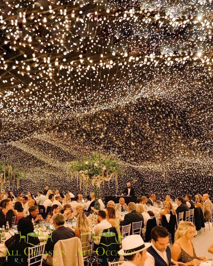 Bistro Lighting Rental set up at a wedding reception, featuring 37.5ft white string lights creating an elegant and warm atmosphere.