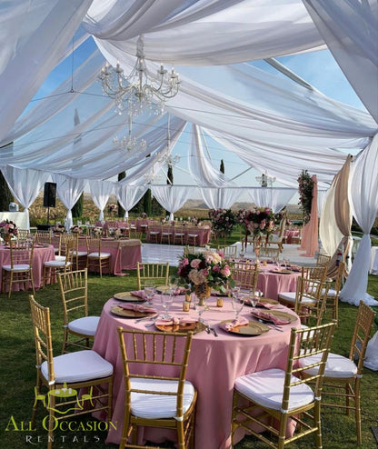 Elegant outdoor reception with pink table linens, chiavari chairs, and crystal chandelier for event rentals in Corona.
