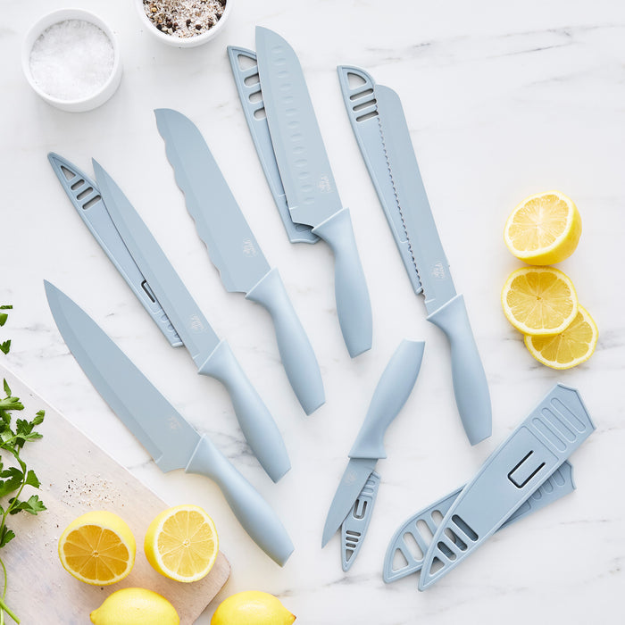 Blue Haze cutlery set with six pieces and blade covers on marble, with lemons and parsley nearby.