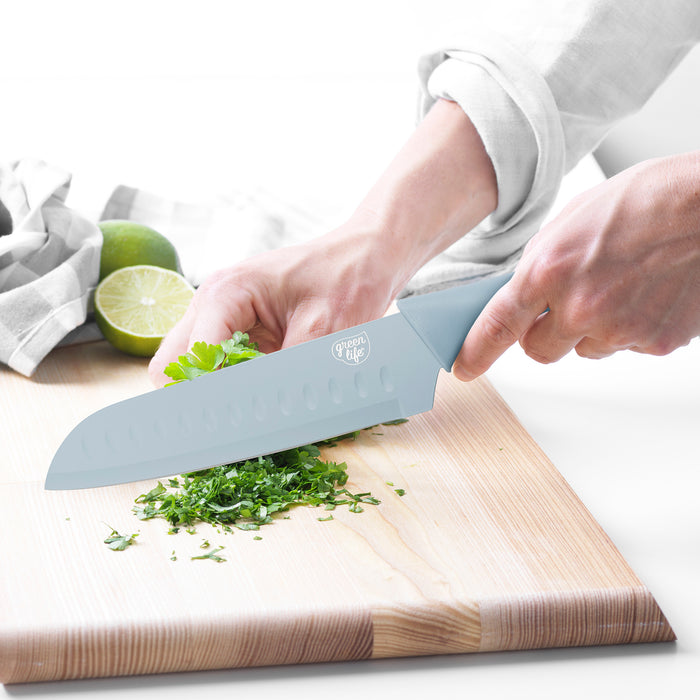 GreenLife 6-piece blue cutlery set used to chop herbs on a wooden board, with a lime visible nearby.