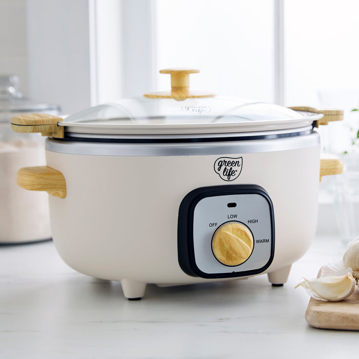 Cream slow cooker with wood-print handles on a light surface