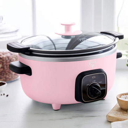 Pink slow cooker with black control panel on a marble countertop