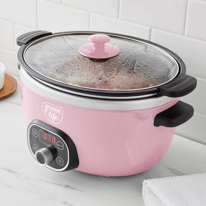 Pink slow cooker with a glass lid on a white countertop