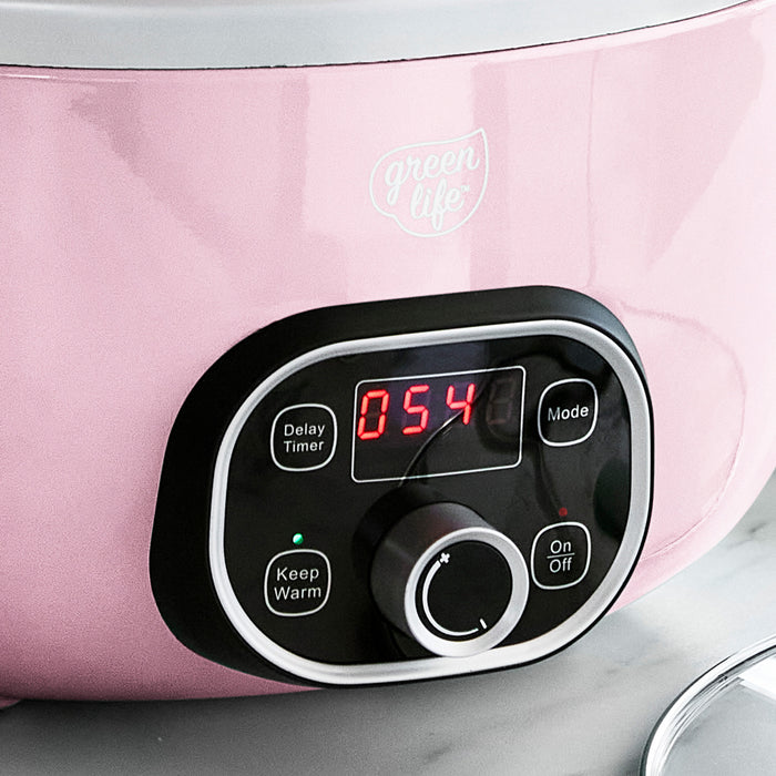 Control panel of a pink slow cooker with digital display and buttons.