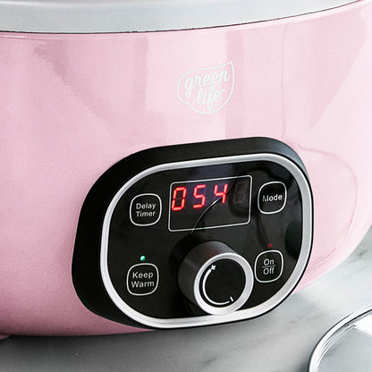 Control panel of a pink slow cooker with digital display and buttons.