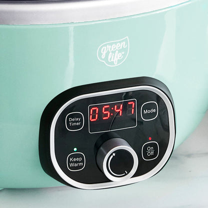 Control panel of a turquoise slow cooker with digital display and buttons.