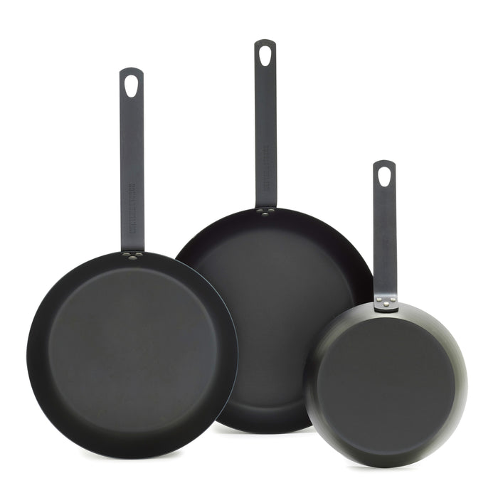 Set of three carbon steel frypans with long handles, sizes 8, 10, and 12, shown upright.