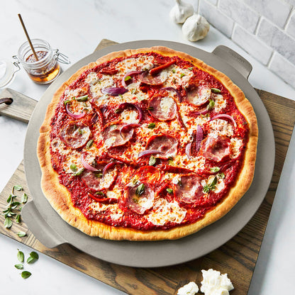 Premiere Ovenware 6-piece ceramic bakeware set with pizza featuring cheese, salami, onions, and herbs.