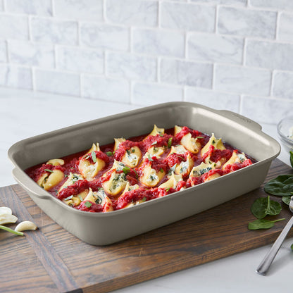 Stuffed pasta shells in tomato sauce with herbs, served in a rectangular white Premiere Ovenware 13x9 baking dish.