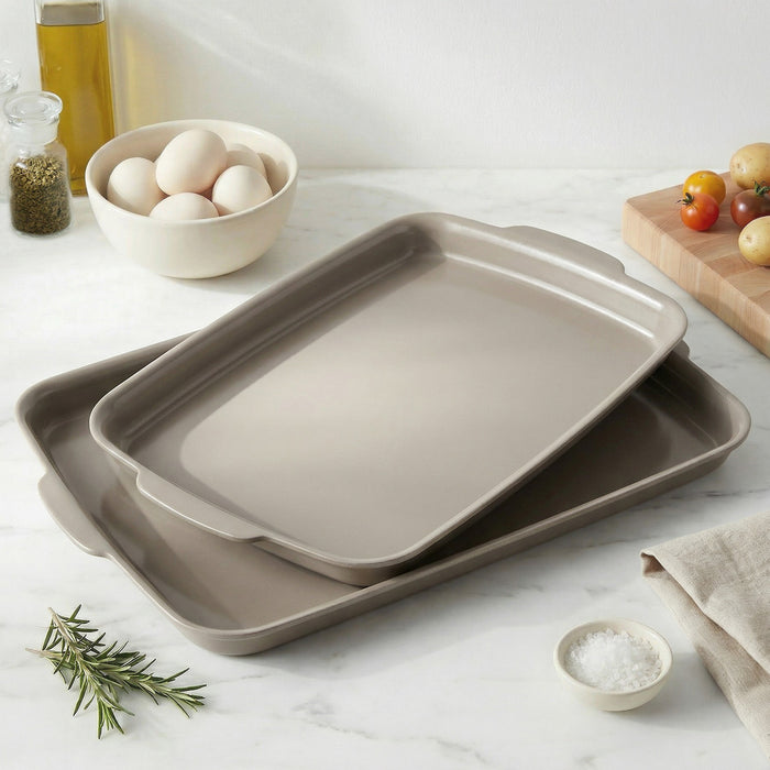 Taupe ceramic nonstick 2-piece sheet pan set on a counter with eggs, fresh herbs, and tomatoes nearby.
