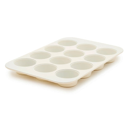 Cream 12-cup muffin pan displayed at an angle on a plain background.