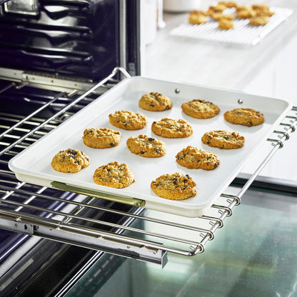 Chocolate chip cookies on a cream half sheet pan and matching cooling rack.