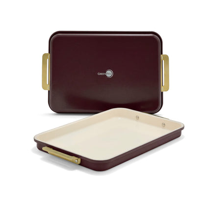 Two burgundy nonstick aluminized steel quarter sheet pans with cream interiors and gold-toned handles.