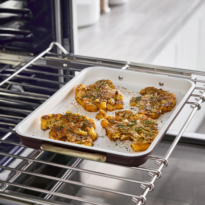 Roasted cauliflower steaks on a Bordeaux Reserve 13″ x 9″ quarter sheet pan inside an oven.