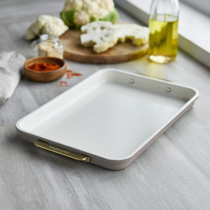 Latte 13″ x 9″ quarter sheet pan made of aluminized steel with gold-tone handles, resting on a wooden surface.