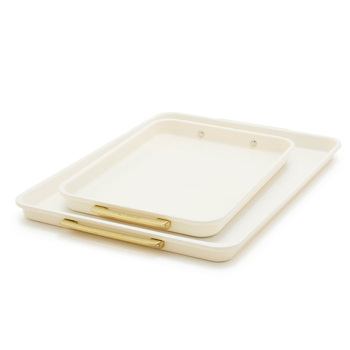 Set of two cream-colored sheet pans with gold handles, one stacked inside the other.