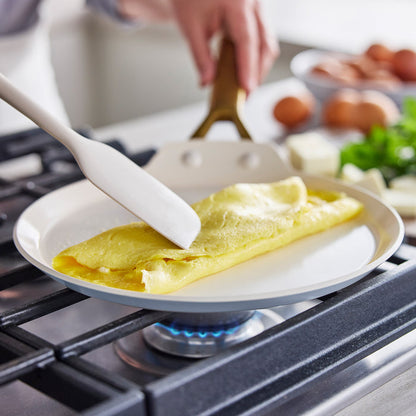 Person cooking an omelette on a stove with a spatula