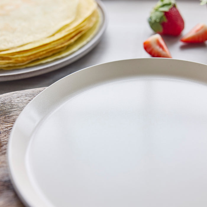 Close-up of a crepe pan with strawberries in the background