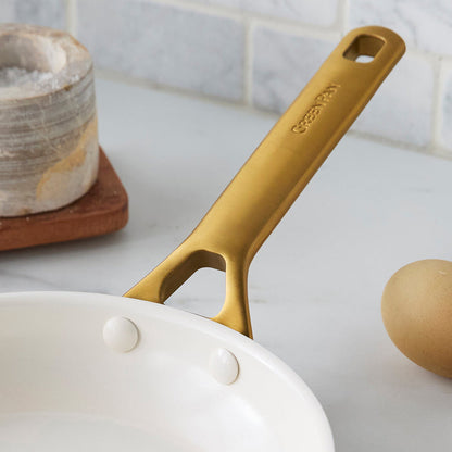 Gold frypan handle on a kitchen counter