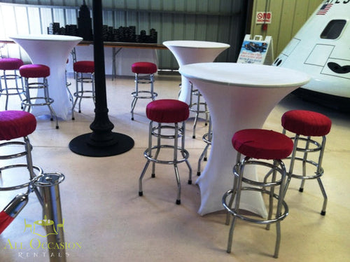 Elegant spandex cocktail tables with red stools for event rentals in Corona, ideal for parties and celebrations.