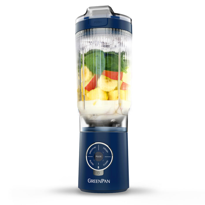 Blue portable blender with fruits inside on a white background