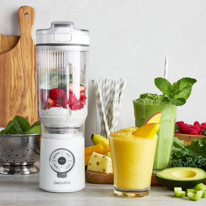 Blender with ingredients and smoothies on a wooden surface