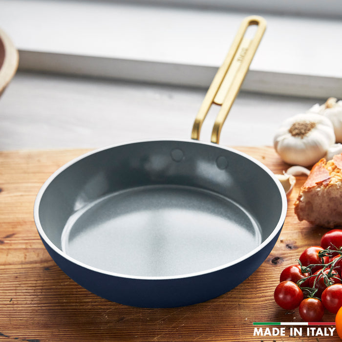 Ceramic nonstick 3-piece mini cookware set in Marino blue with gold handles on a wooden countertop.