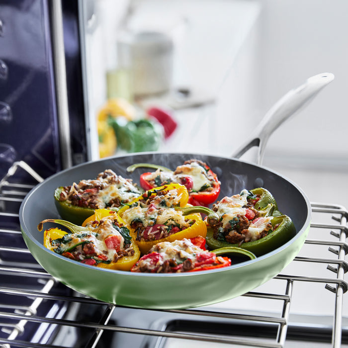 Stuffed bell peppers in a cream frypan on an oven rack